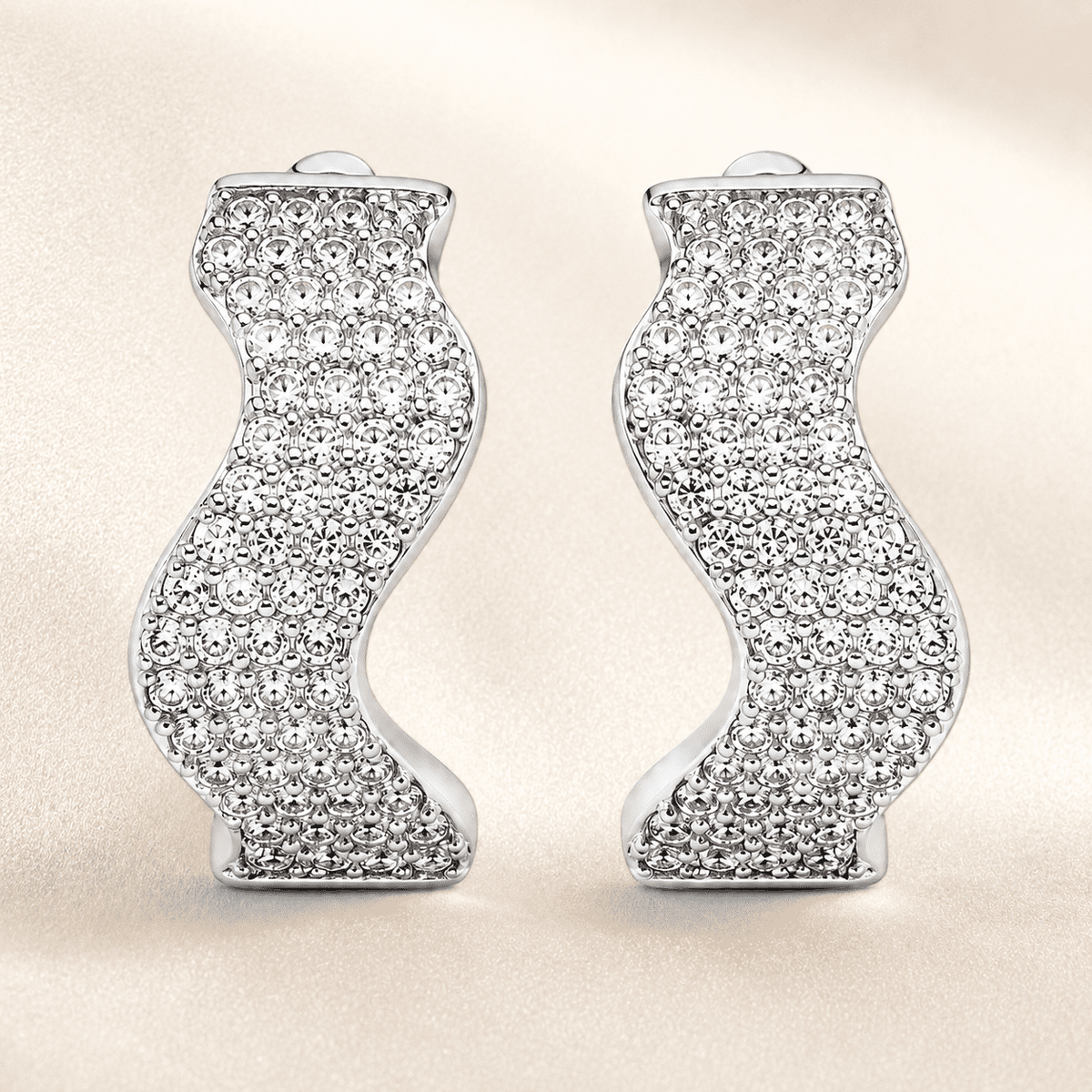 The Ocean Ripple Huggies — Silver-Tone Wave Huggie Earrings by House of Zena, worn on model